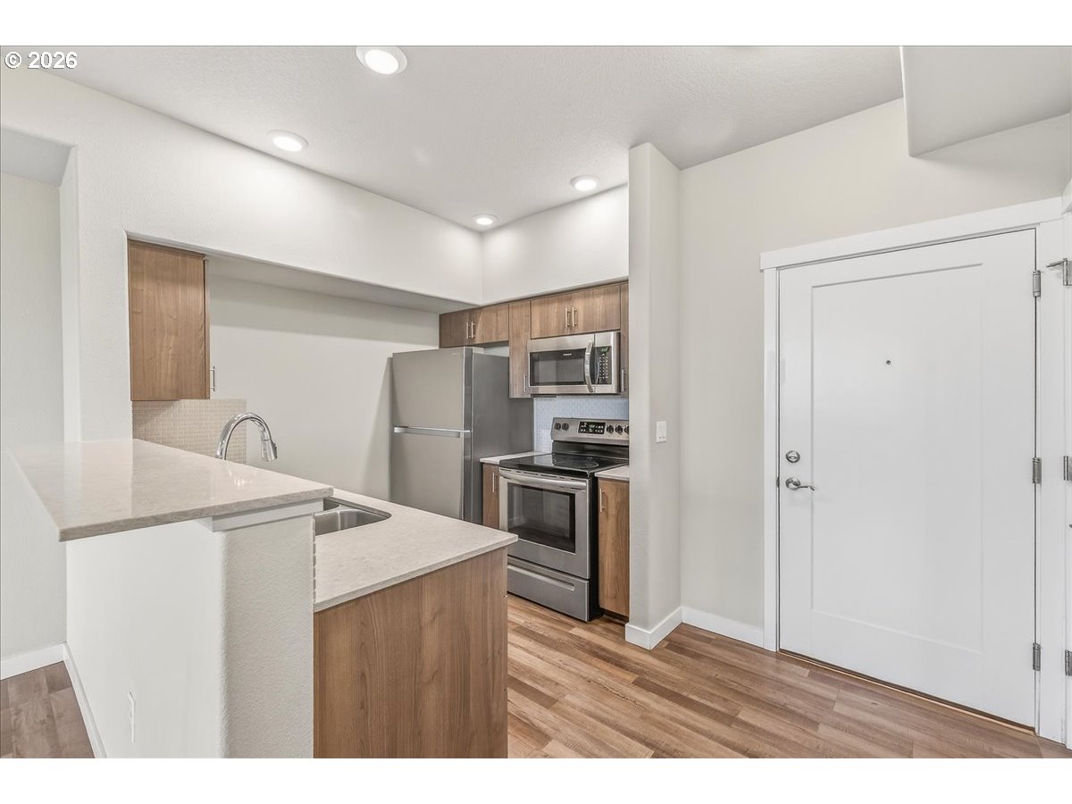 16401 Northwest Chadwick Way, Unit 108 Portland, OR 97229 - Photo 12 of 29 a kitchen with stainless steel appliances a refrigerator and a stove top oven
