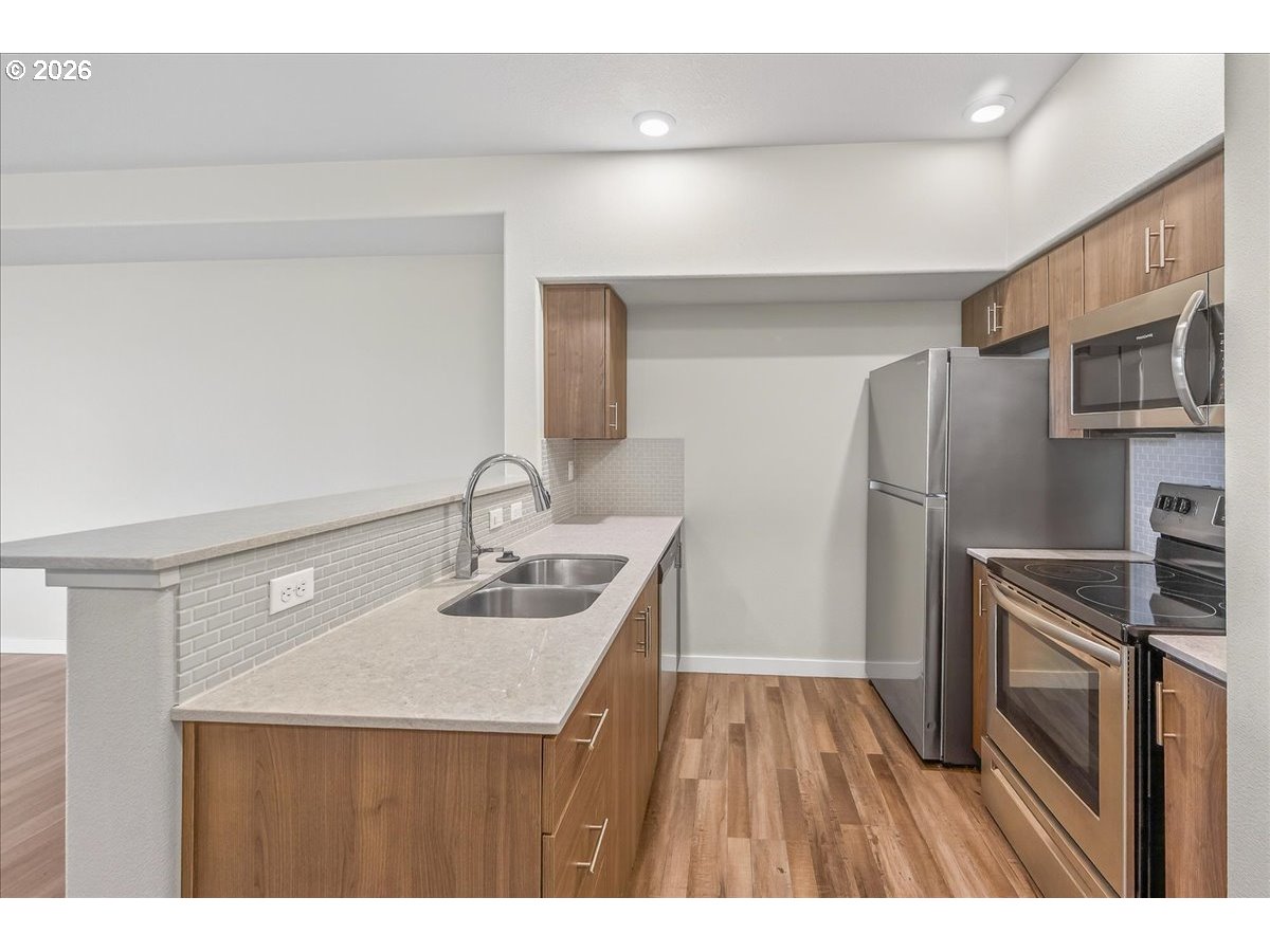 16401 Northwest Chadwick Way, Unit 108 Portland, OR 97229 - Photo 13 of 29 a kitchen with kitchen island a sink appliances and cabinets