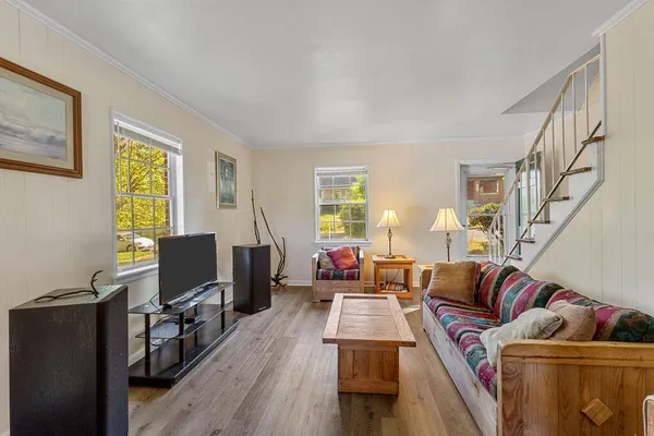 a living room with furniture a flat screen tv and wooden floor