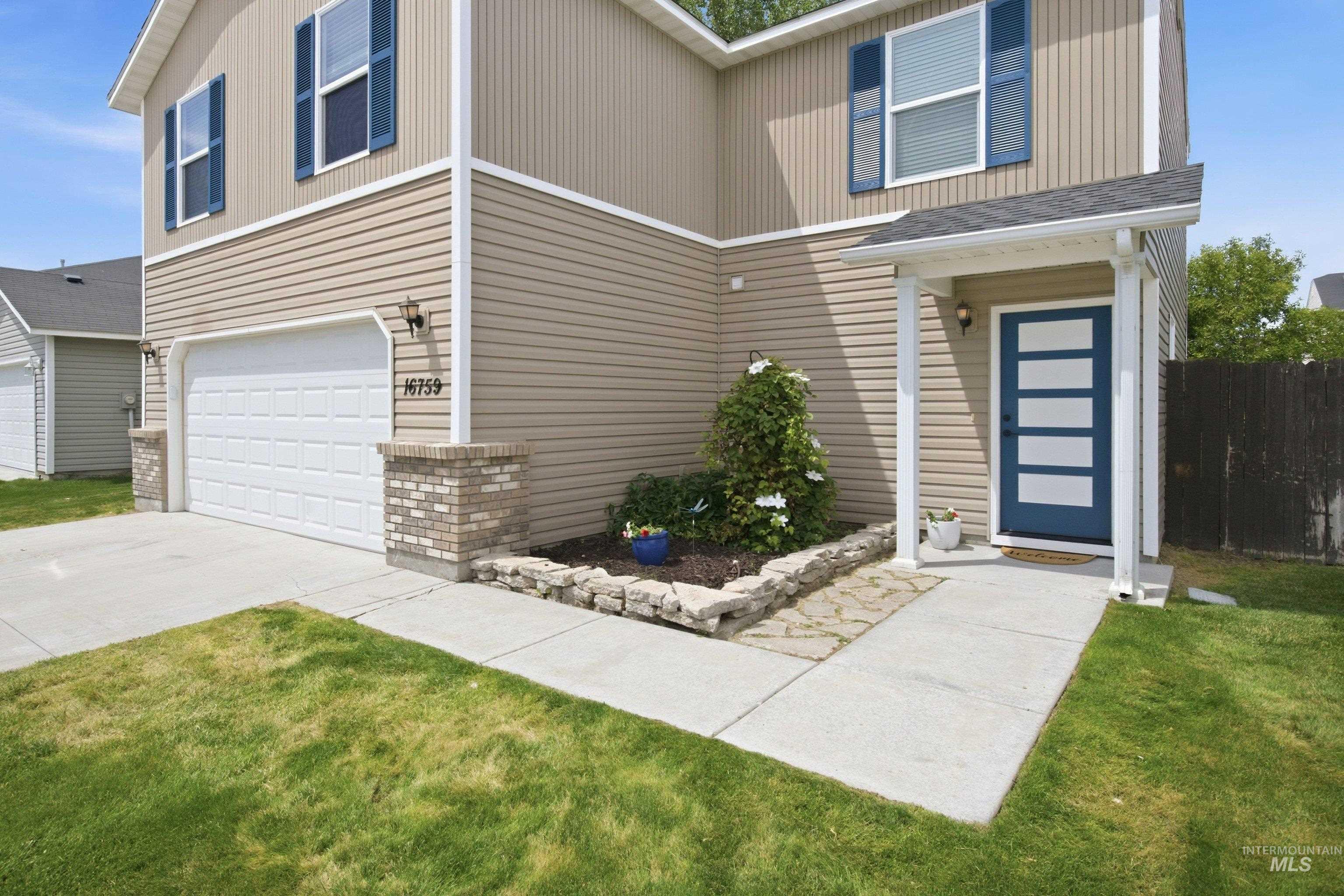 16759 Abram Avenue Caldwell, ID 83607 - Photo 5 of 33 Two-story exterior with beige horizontal siding and blue-shuttered windows