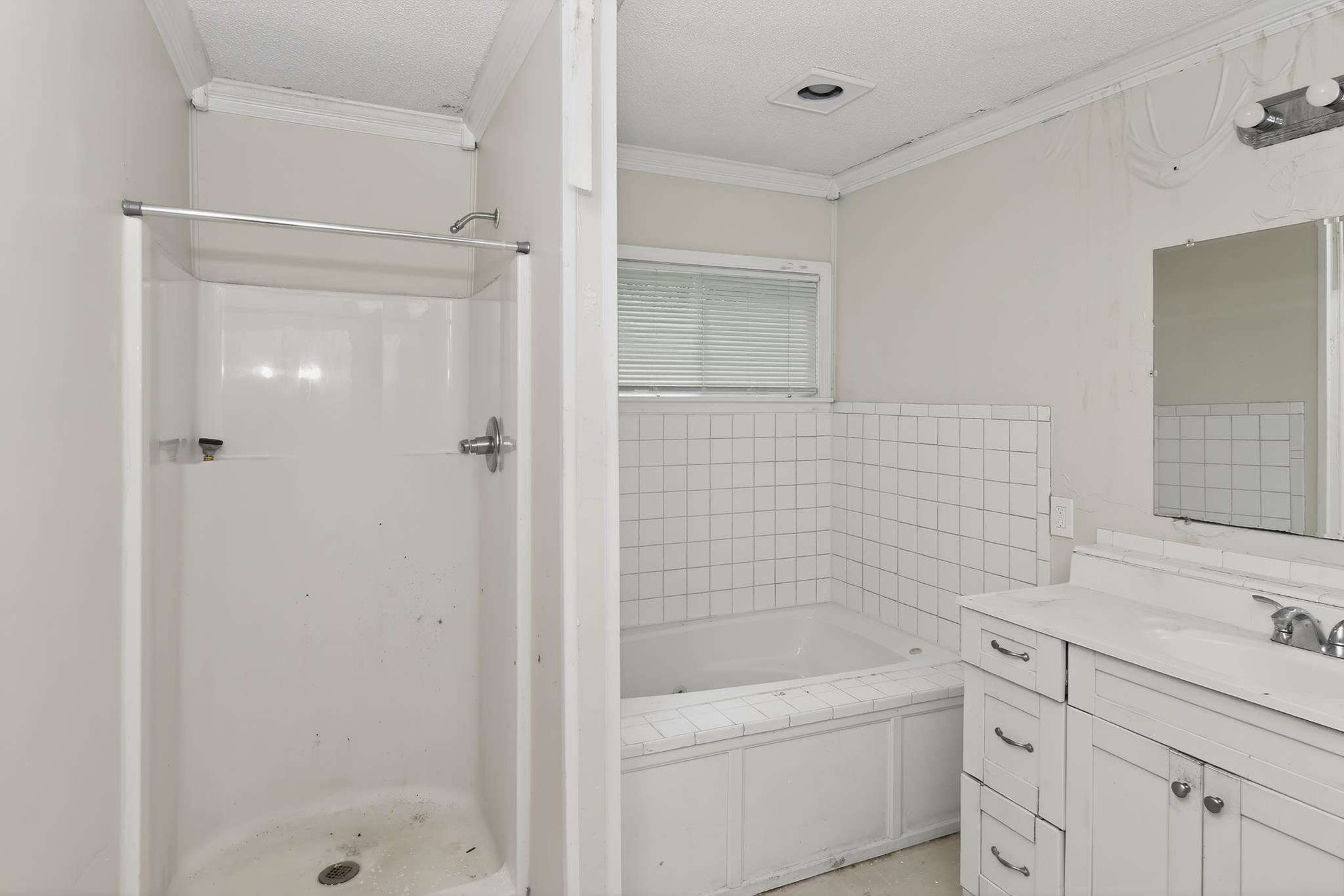 1403 Old Hickory Road Memphis, TN 38116 - Photo 24 of 31 Bathroom featuring a separate shower stall, a built-in bathtub with tiled surround, a window with blinds, and a vanity with an integrated sink and cabinet storage