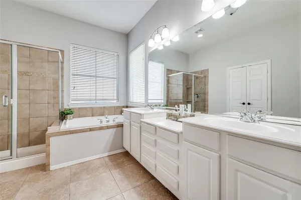 a large bathroom with a double vanity sink large mirror and a bathtub