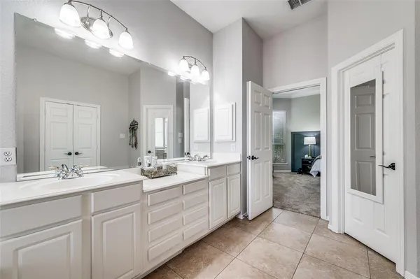 a spacious en suite bathroom with double sink and a mirror