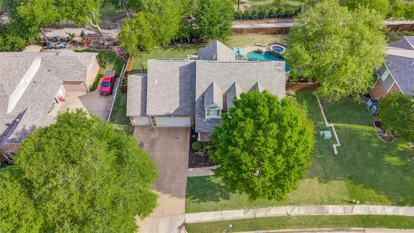 an aerial view of a house with a yard and a large tree