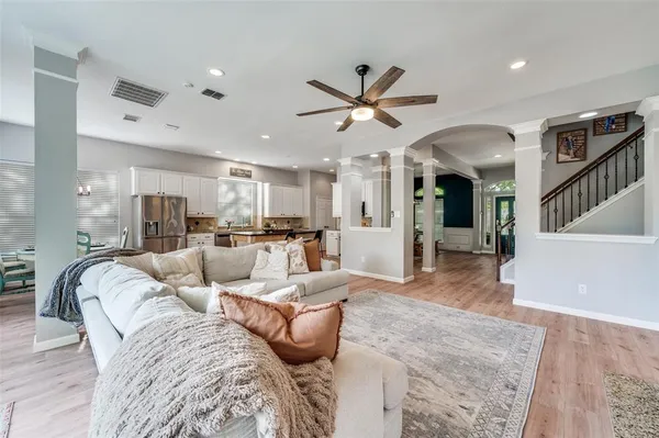 a living room with furniture and a view of kitchen