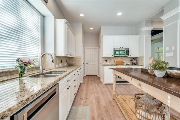 a large kitchen with granite countertop a sink and a stove