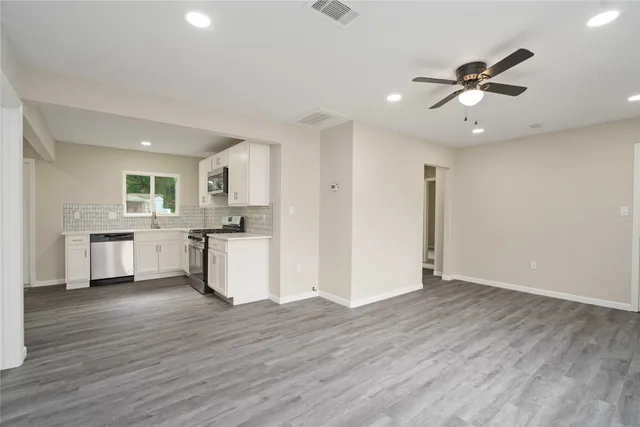 a view of a kitchen with wooden floor and a ceiling fan
