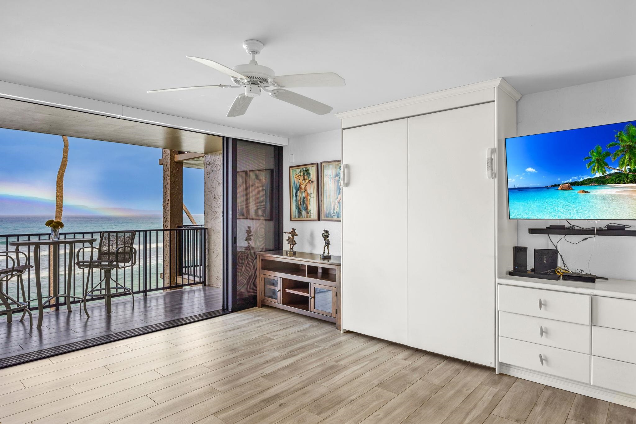 3543 Lower Honoapiilani Road, Unit F303 Lahaina, HI 96761 - Photo 3 of 20 a view of a kitchen with furniture a ceiling fan and wooden floor