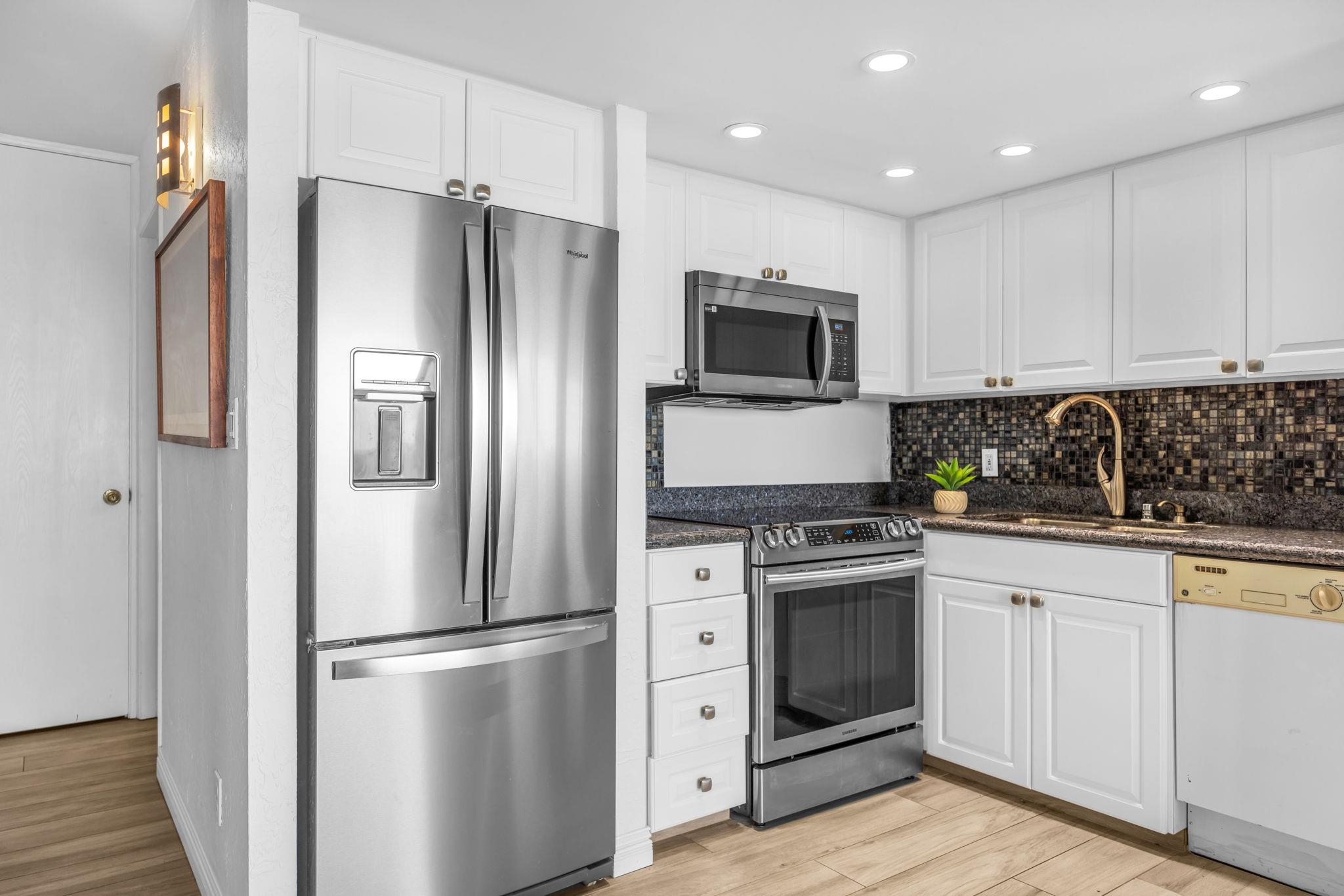 3543 Lower Honoapiilani Road, Unit F303 Lahaina, HI 96761 - Photo 4 of 20 a kitchen with cabinets stainless steel appliances and wooden floor