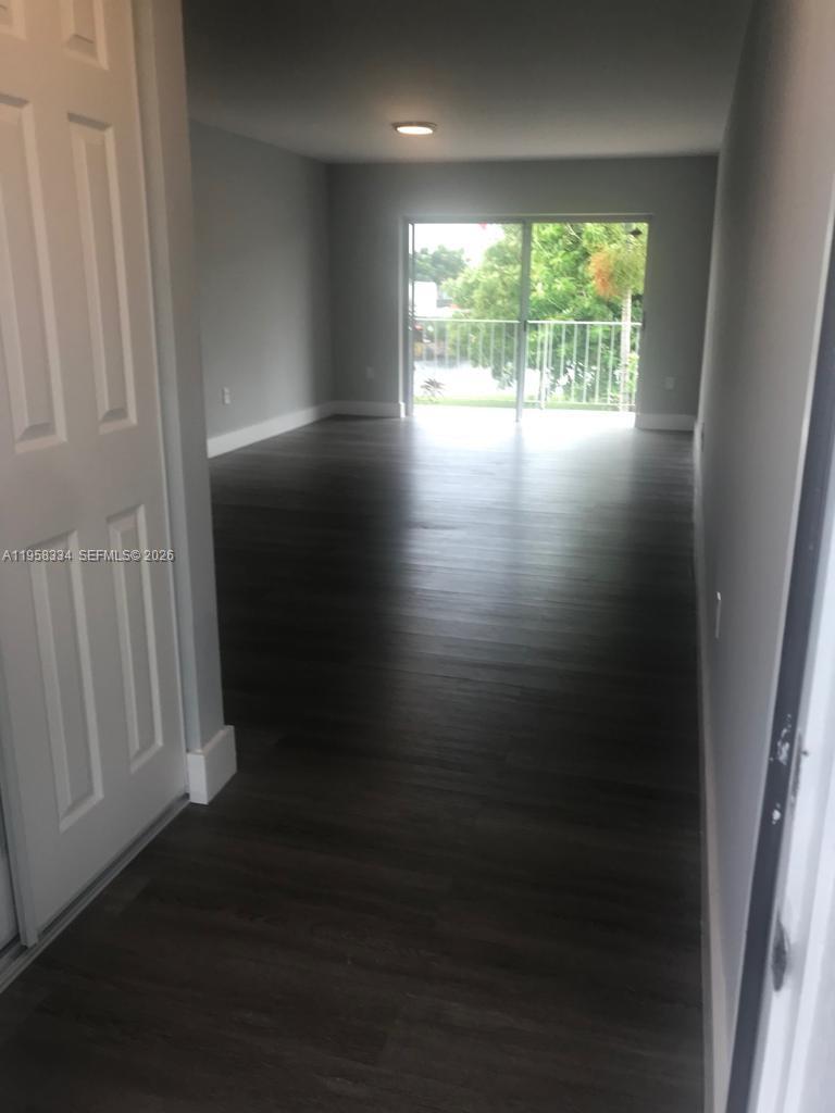 7570 Southwest 82nd Street, Unit F209 Miami, FL 33143 - Photo 2 of 13 a view of empty room with wooden floor and fan