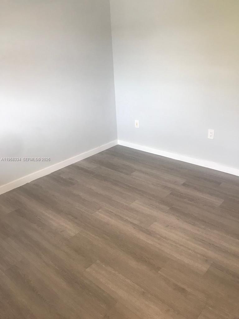7570 Southwest 82nd Street, Unit F209 Miami, FL 33143 - Photo 9 of 13 wooden floor in empty room
