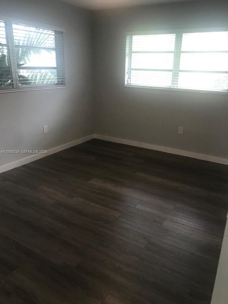 7570 Southwest 82nd Street, Unit F209 Miami, FL 33143 - Photo 10 of 13 an empty room with wooden floor and windows