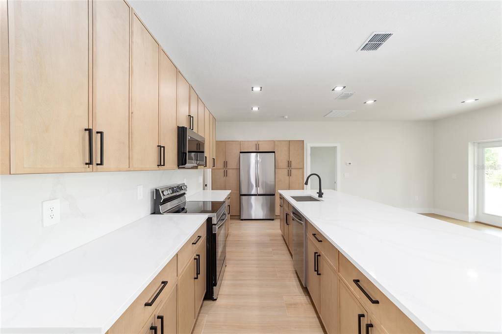 4380 Southwest 159th Court Ocala, FL 34481 - Photo 16 of 52 a large kitchen with stainless steel appliances sink a microwave and cabinets