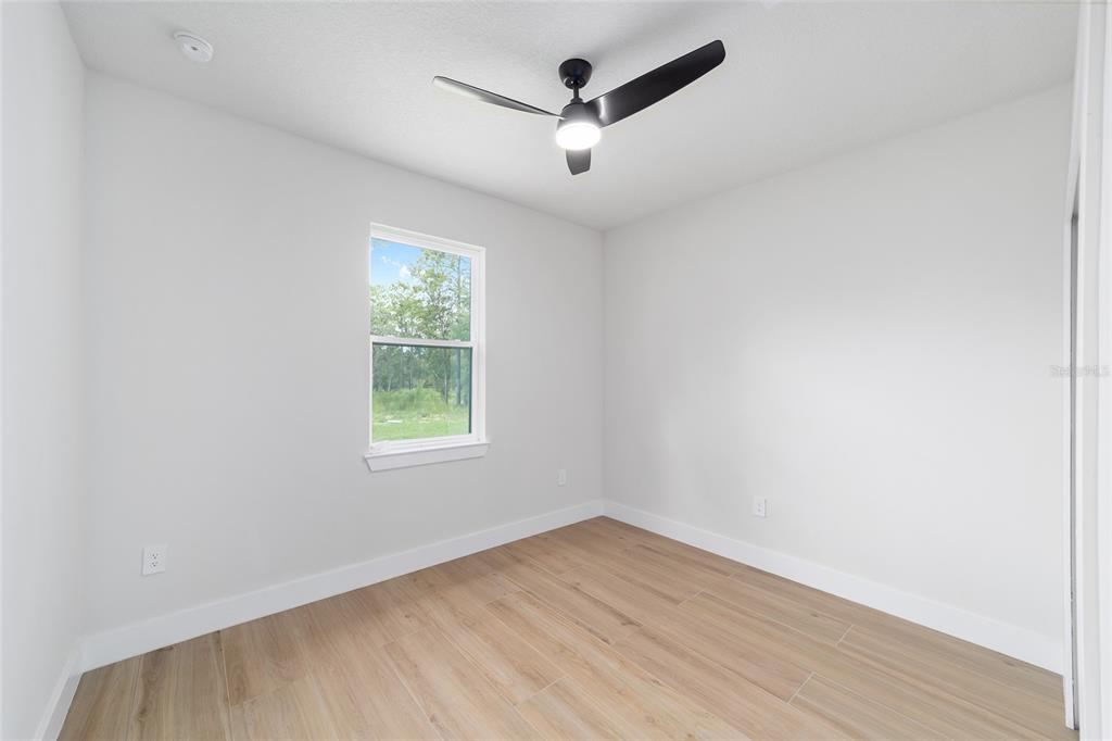 4380 Southwest 159th Court Ocala, FL 34481 - Photo 23 of 52 an empty room with wooden floor and windows