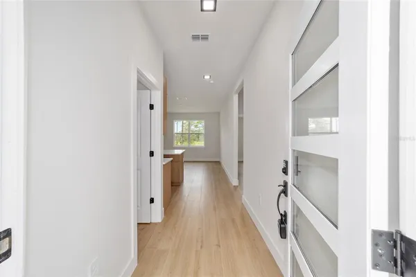 a view of a hallway with wooden floor and staircase