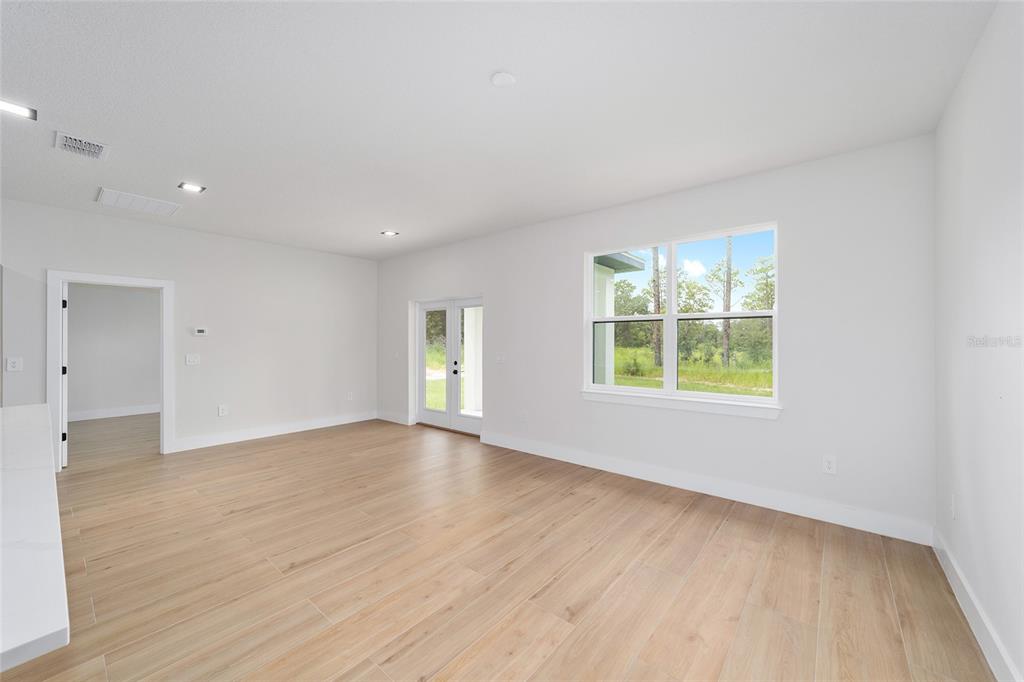 4380 Southwest 159th Court Ocala, FL 34481 - Photo 6 of 52 an empty room with wooden floor and windows