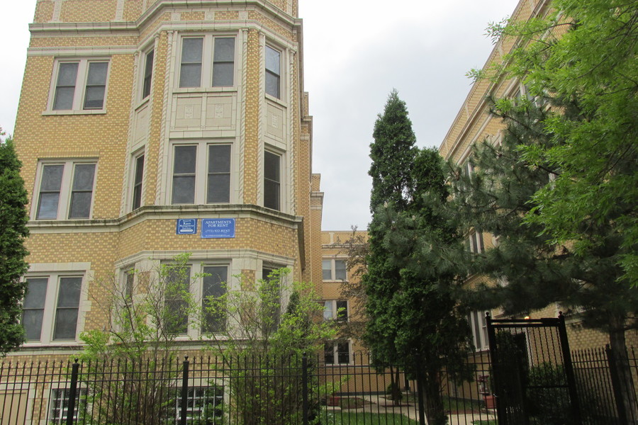 a front view of a residential apartment building with a yard