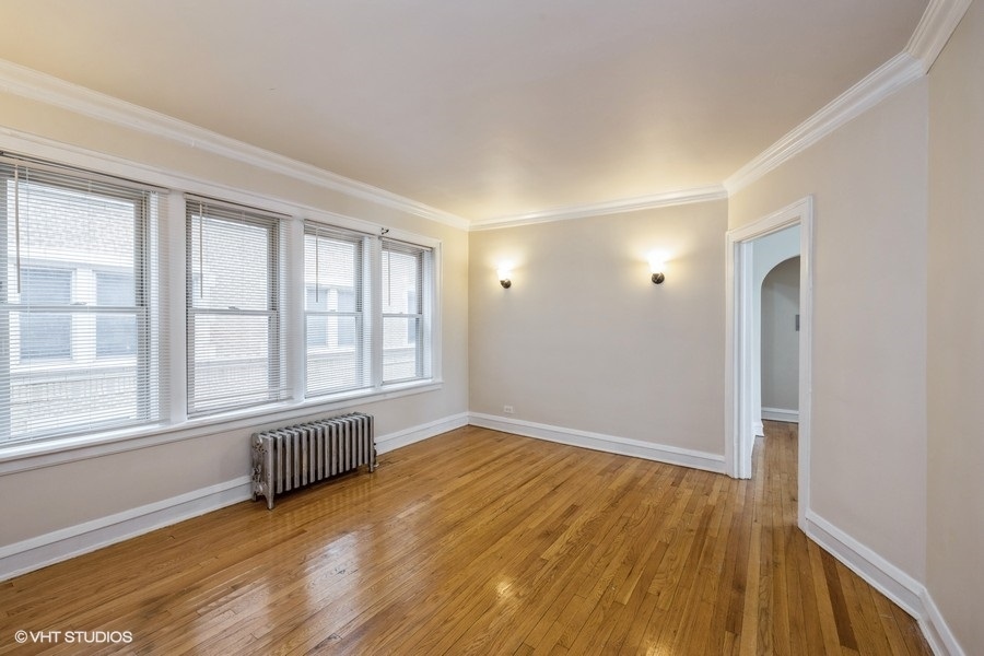 1725 West 91st Street, Unit 1 Chicago, IL 60620 - Photo 2 of 7 a view of an empty room with wooden floor and a window