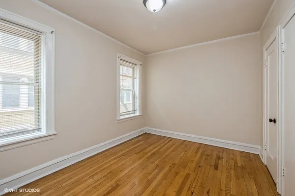 a room with wooden floor and windows