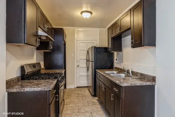 a kitchen with stainless steel appliances granite countertop a stove a refrigerator and a sink