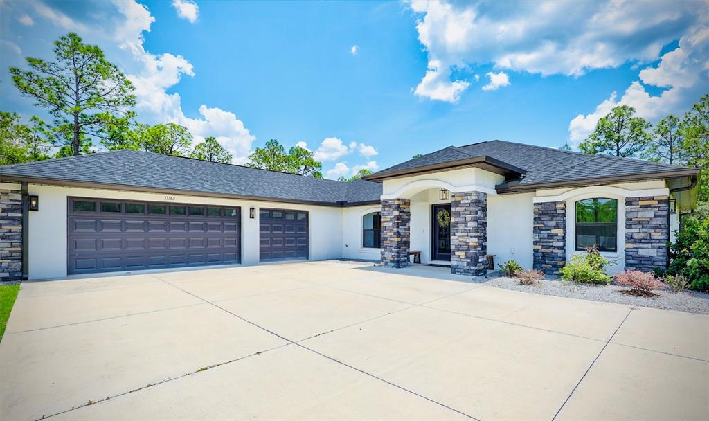13362 Downy Woodpecker Road Weeki Wachee, FL 34614 - Photo 1 of 26 a view of a house with potted plants and a large tree