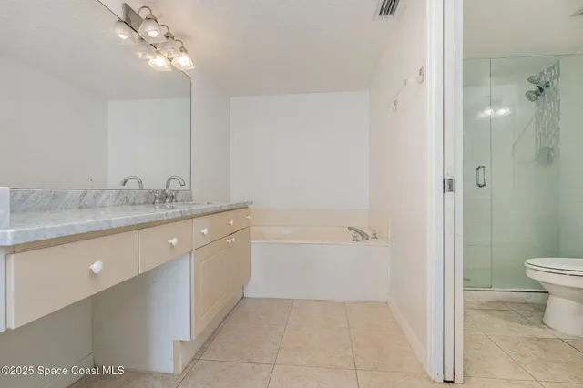 a spacious bathroom with a granite countertop sink a toilet and shower