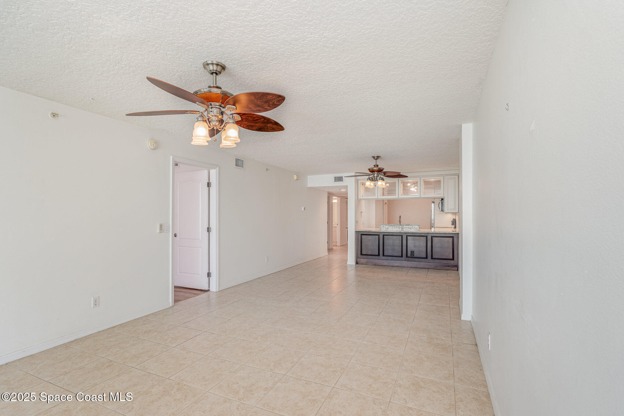 1575 North Hwy A1A, Unit 613 Indialantic, FL 32903 - Photo 7 of 23 a view of a livingroom with a chandelier fan and kitchen view