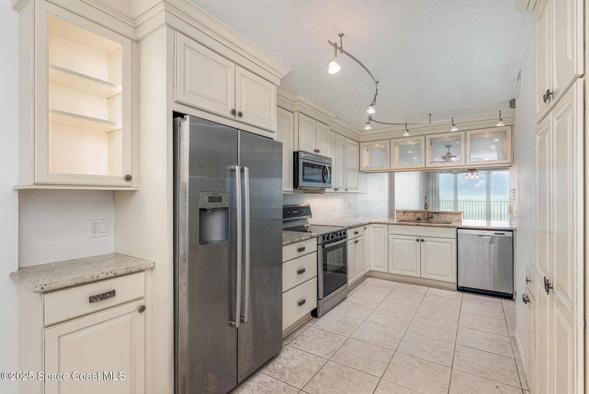1575 North Hwy A1A, Unit 613 Indialantic, FL 32903 - Photo 8 of 23 a kitchen with stainless steel appliances granite countertop a refrigerator and a stove top oven