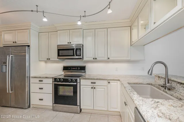 a kitchen with granite countertop a sink stainless steel appliances and cabinets