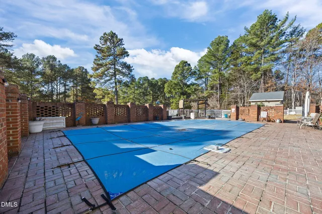 a view of a patio with table and chairs and couches with wooden fence