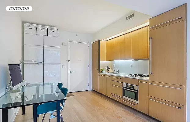 a kitchen with appliances cabinets and wooden floor