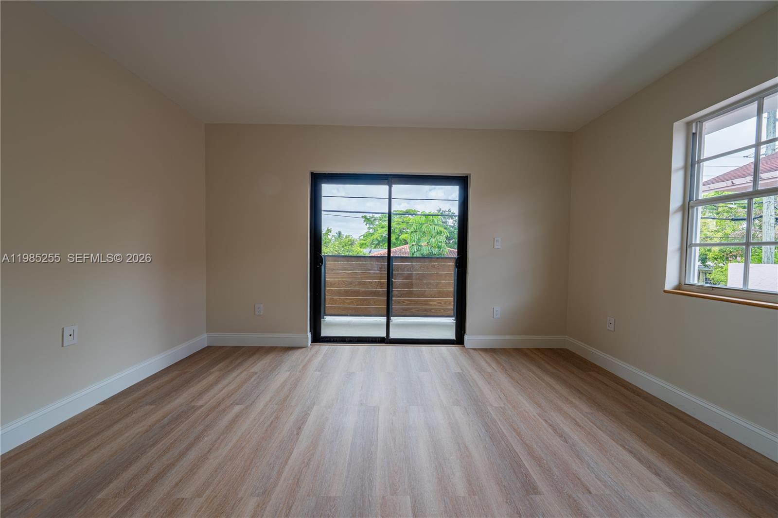 370 Flagami Boulevard Miami, FL 33144 - Photo 13 of 67 an empty room with wooden floor and windows
