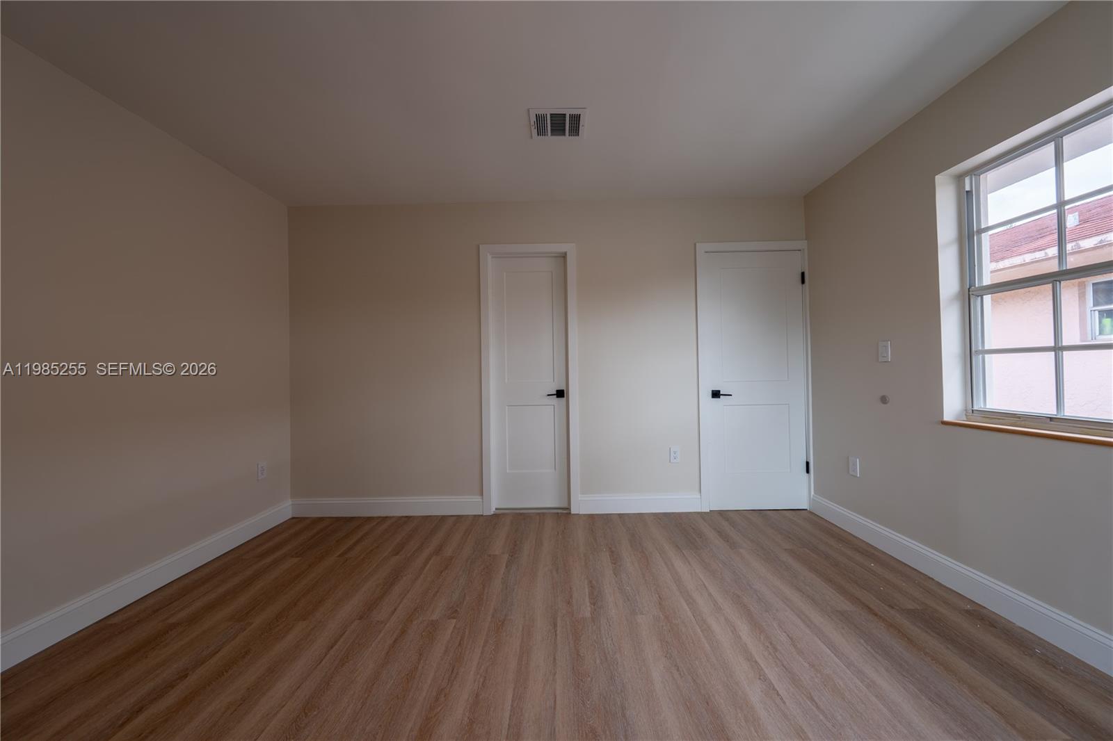 370 Flagami Boulevard Miami, FL 33144 - Photo 29 of 67 wooden floor in an empty room with a window