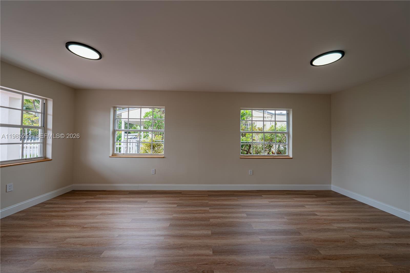 370 Flagami Boulevard Miami, FL 33144 - Photo 7 of 67 an empty room with wooden floor and windows