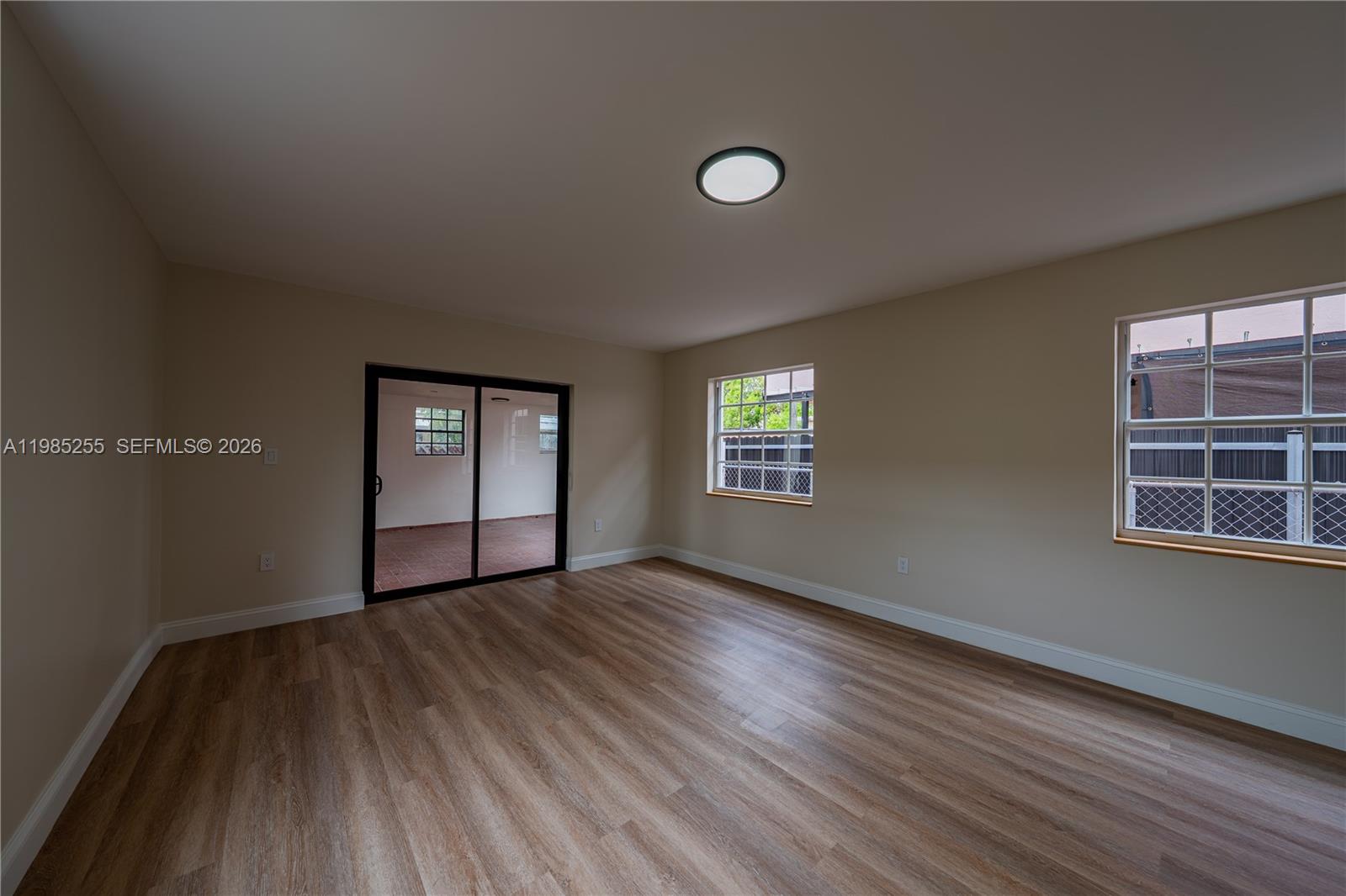 370 Flagami Boulevard Miami, FL 33144 - Photo 8 of 67 an empty room with wooden floor and windows