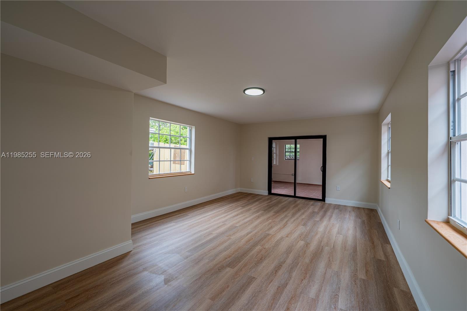 370 Flagami Boulevard Miami, FL 33144 - Photo 10 of 67 an empty room with wooden floor and windows
