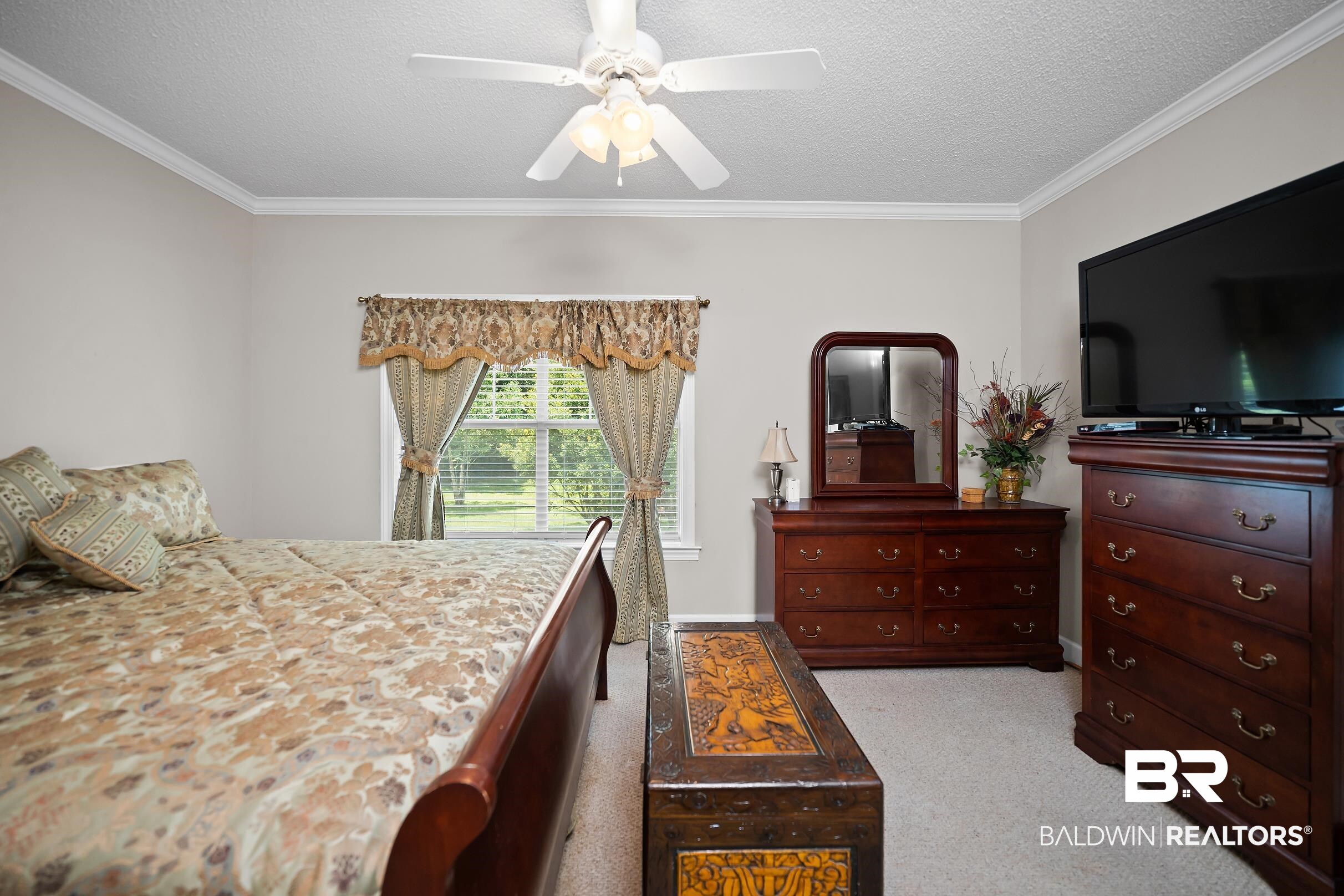 430 West Fort Morgan Road, Unit 704 Gulf Shores, AL 36542 - Photo 12 of 35 Carpeted room featuring a ceiling fan with integrated lighting, crown molding, and a window with blinds overlooking greenery