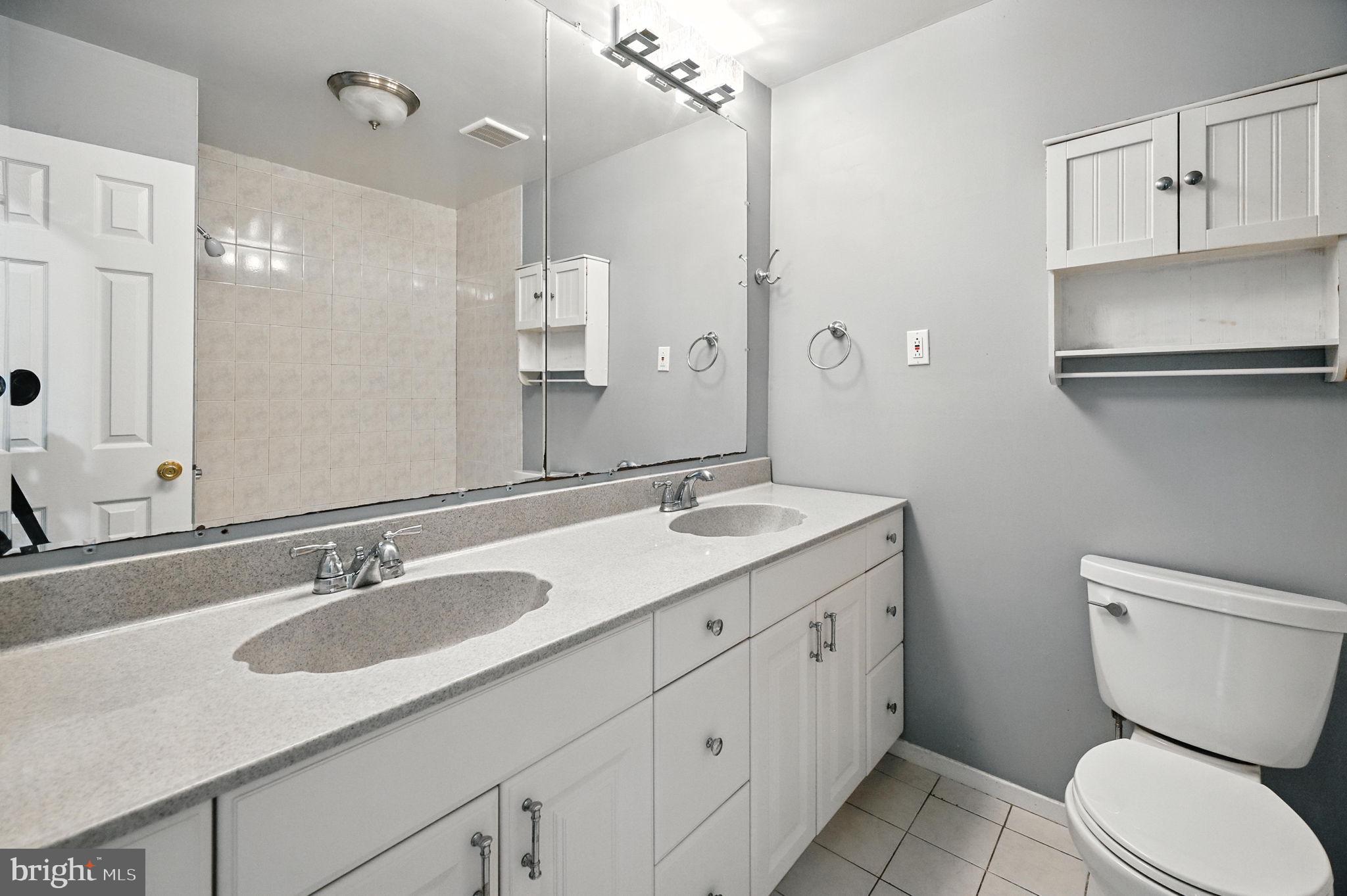 9301 Montpelier Drive Laurel, MD 20708 - Photo 12 of 23 a bathroom with a granite countertop toilet sink and a mirror