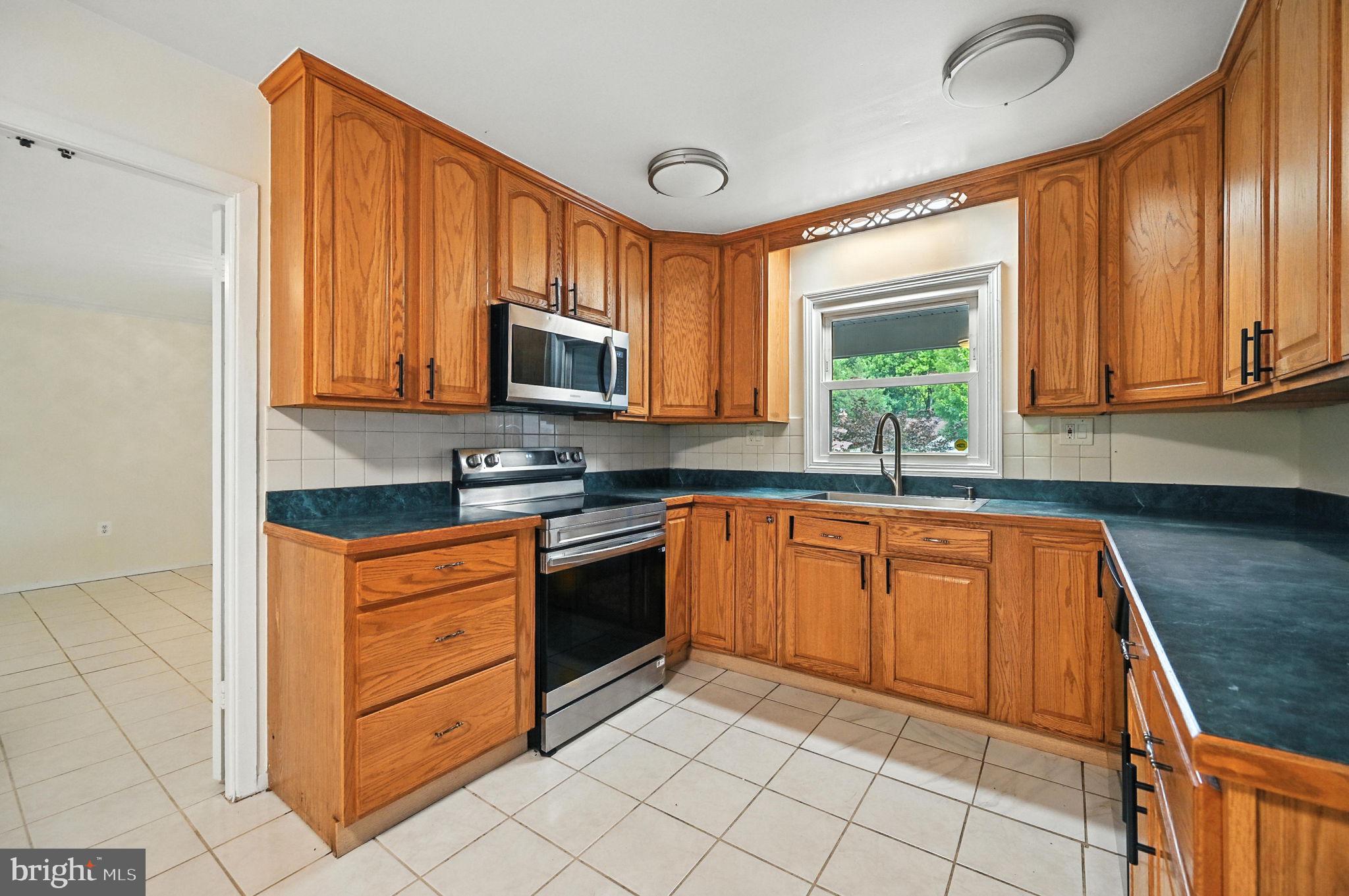 9301 Montpelier Drive Laurel, MD 20708 - Photo 7 of 23 a kitchen with stainless steel appliances granite countertop a stove sink and microwave