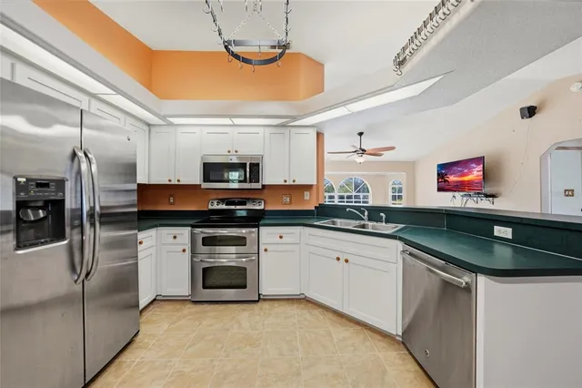 a kitchen with granite countertop a sink stainless steel appliances and cabinets