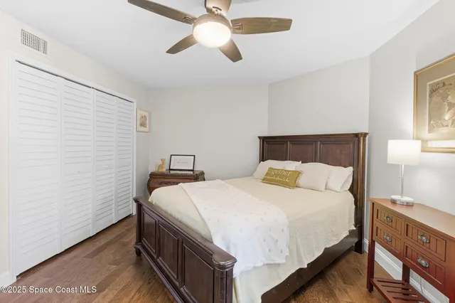 a large bedroom with a bed and a large mirror with a dresser