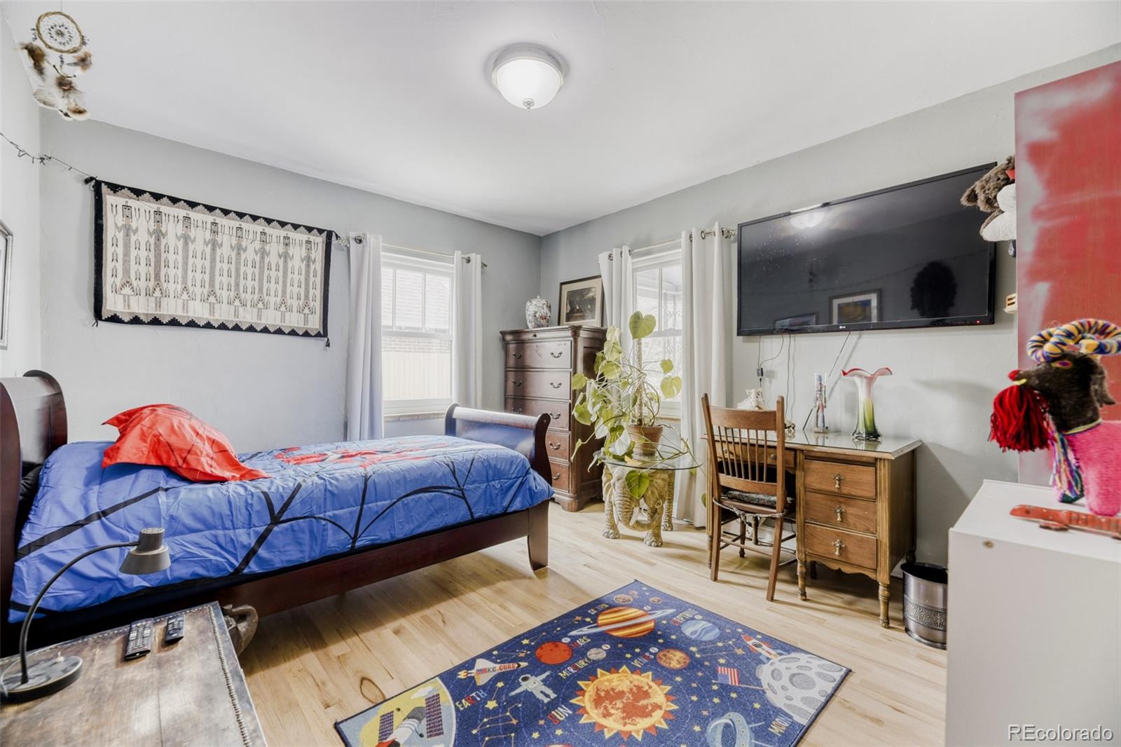 2520 North Locust Street Denver, CO 80207 - Photo 17 of 39 a living room with furniture a flat screen tv and paintings on the wall