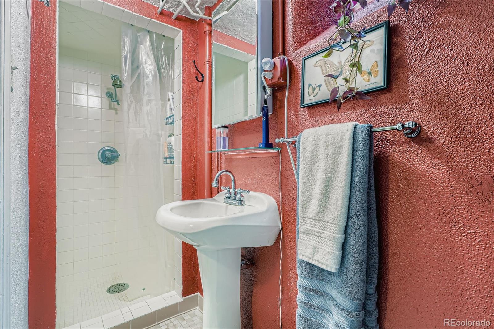 2520 North Locust Street Denver, CO 80207 - Photo 23 of 39 a bathroom with a sink a mirror and shower