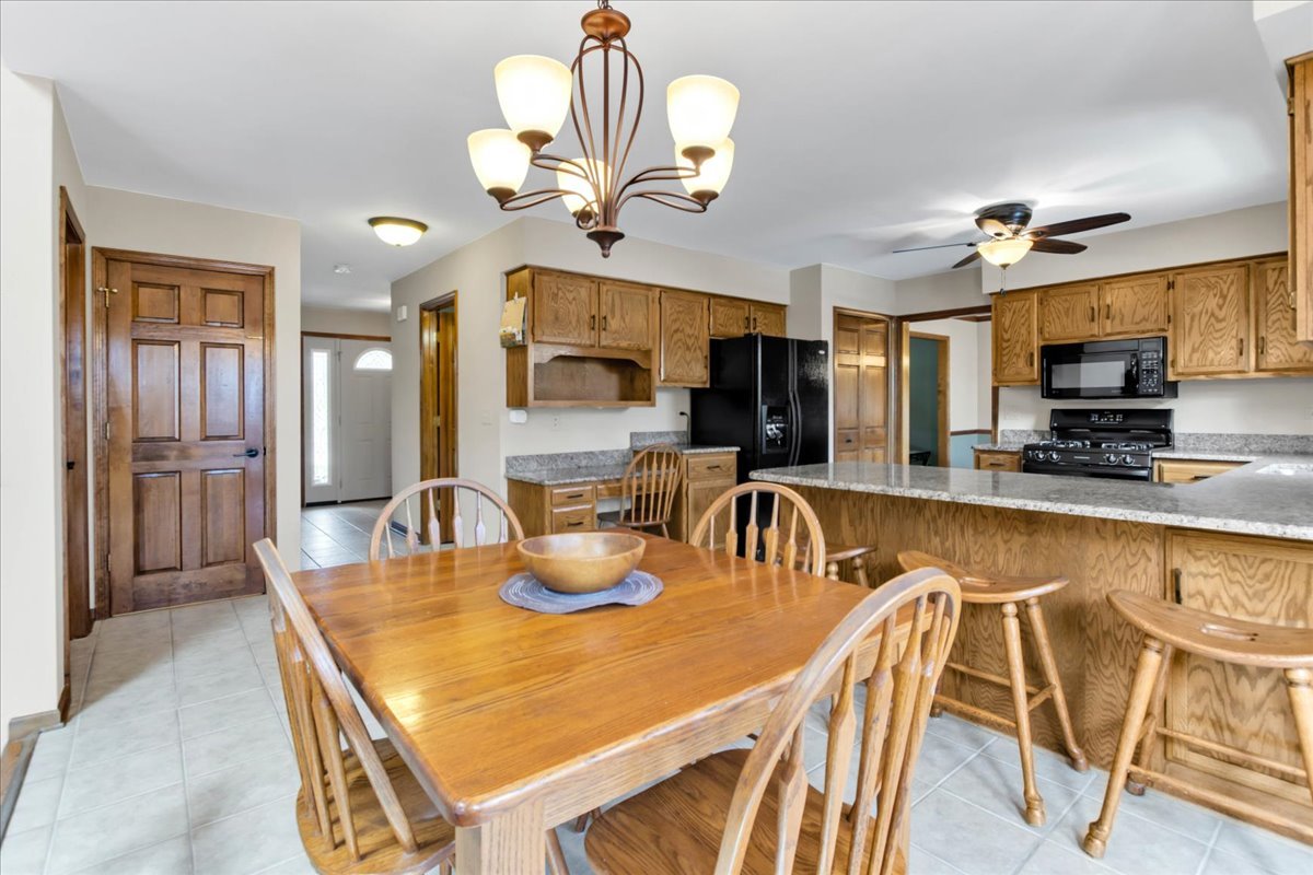 76 Red Fox Run Montgomery, IL 60538 - Photo 9 of 28 a dining room with a table chairs and a chandelier