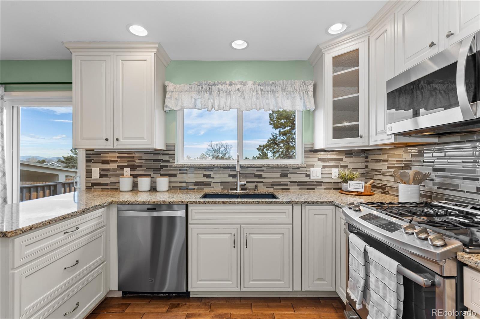 8503 South Woody Way Highlands Ranch, CO 80126 - Photo 15 of 45 a kitchen with granite countertop a stove sink and cabinets