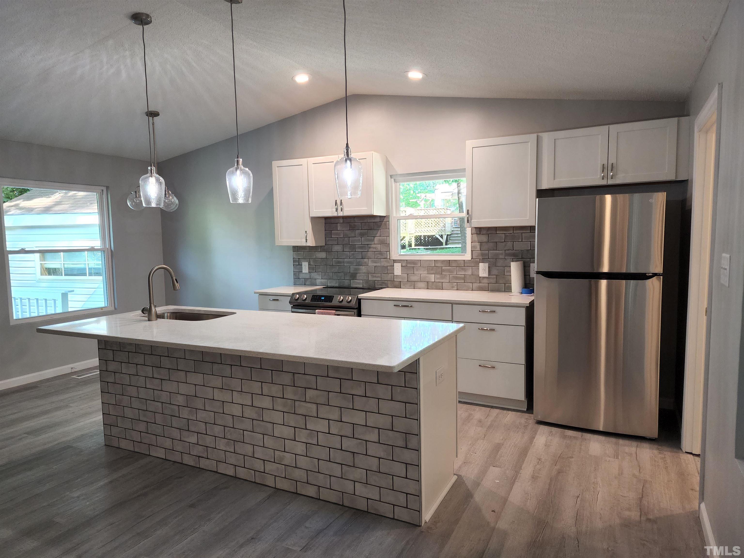 104 Trappers Run Drive Cary, NC 27513 - Photo 3 of 13 a kitchen with stainless steel appliances granite countertop a sink a refrigerator a center island a stove and a window