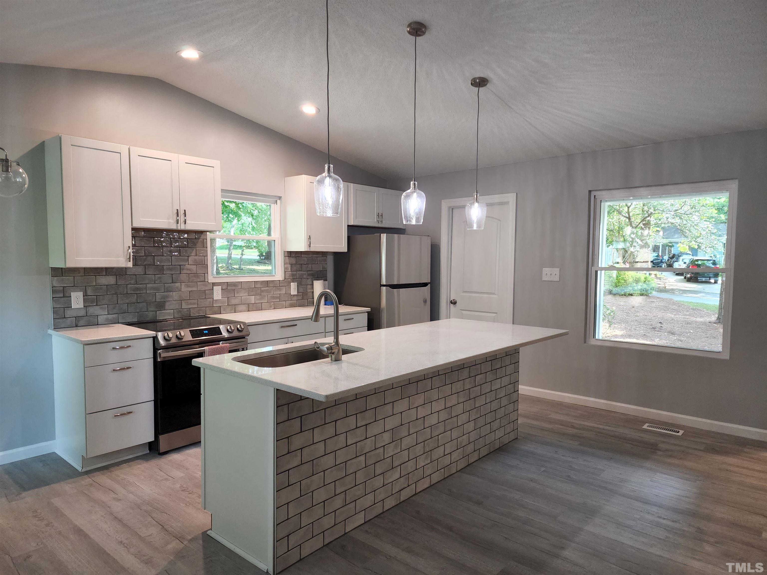 104 Trappers Run Drive Cary, NC 27513 - Photo 4 of 13 a kitchen with kitchen island granite countertop a sink stainless steel appliances and cabinets
