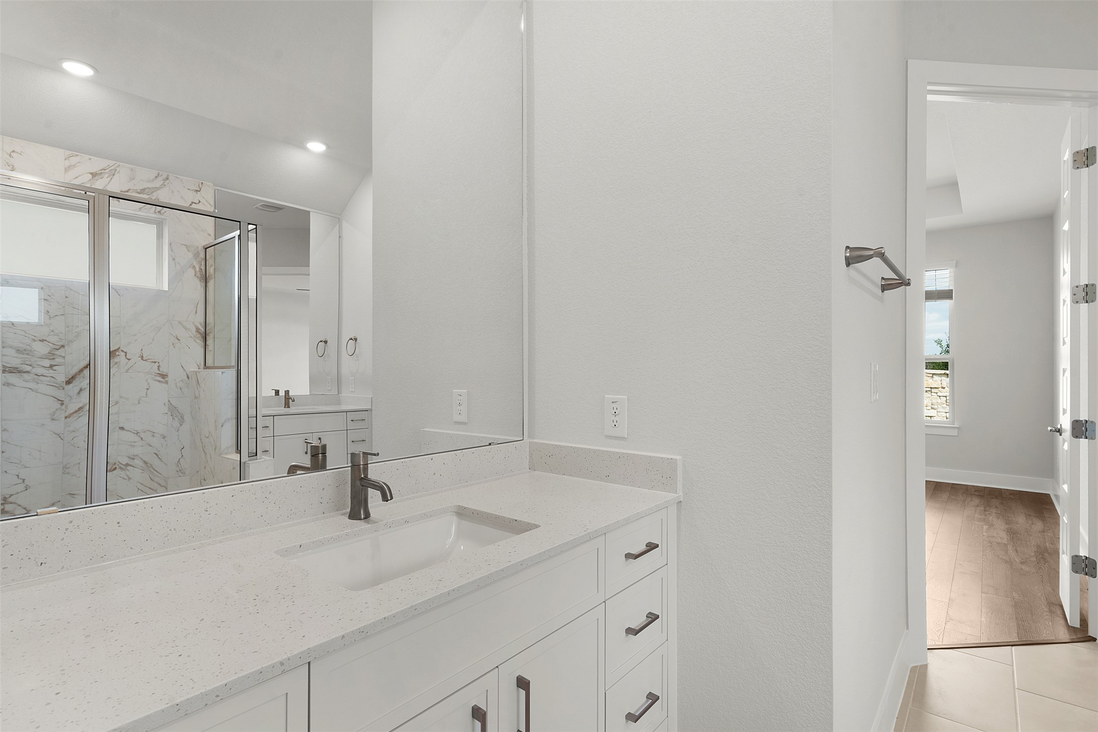 1129 Pansy Trail Georgetown, TX 78628 - Photo 18 of 29 Bathroom vanity featuring a rectangular undermount sink, quartz countertop, dark bronze faucet, and white cabinetry with dark bronze hardware