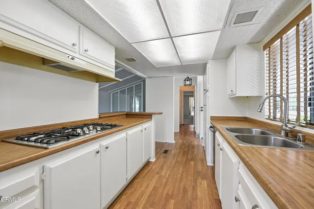 a kitchen with stainless steel appliances granite countertop a sink and wooden cabinets