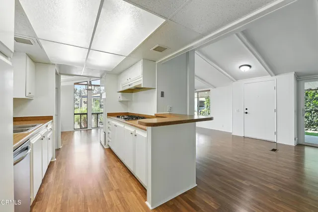 a large kitchen with cabinets wooden floor and stainless steel appliances